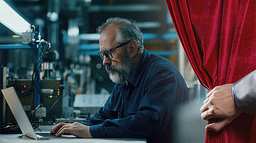 A curtain pulled aside reveals a technician behind the scenes, illustrating how technical specifications are transformed into test tools.